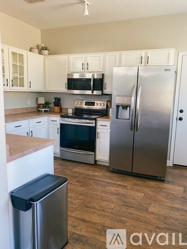 A kitchen with a refrigerator, oven, and microwave.