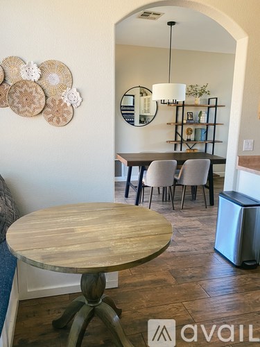 A dining room with a round wooden table and chairs.