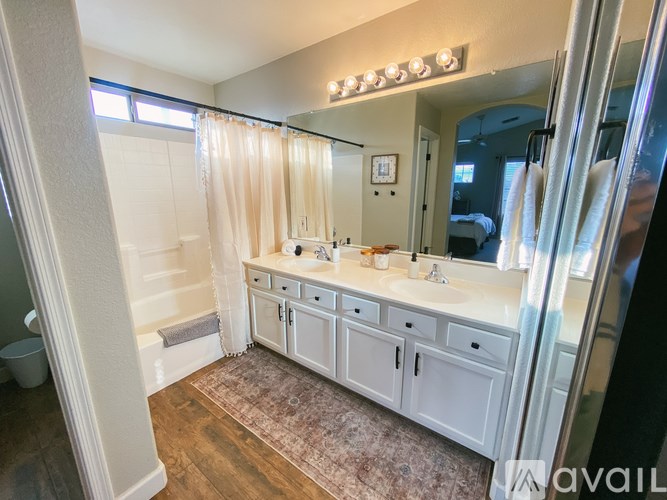 A bathroom with a vanity, mirror, and lighting fixture.