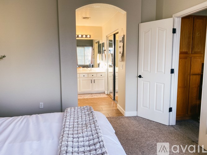 A bedroom with a bed and a carpeted floor.
