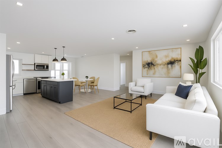 A modern living room with a white sofa, a coffee table, and a dining table with chairs.