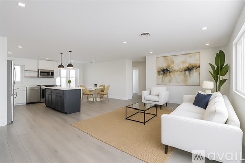 A modern living room with a white sofa, a coffee table, and a dining table with chairs.