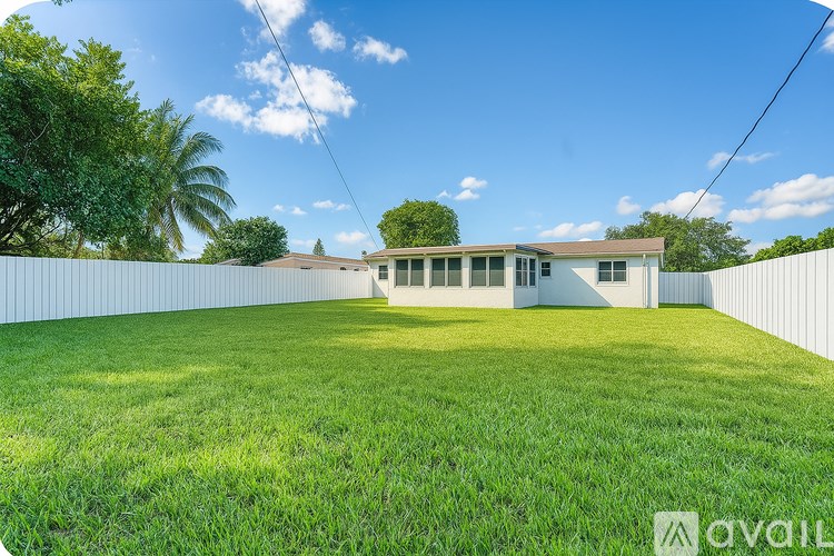 A house with a white fence and green grass in front.