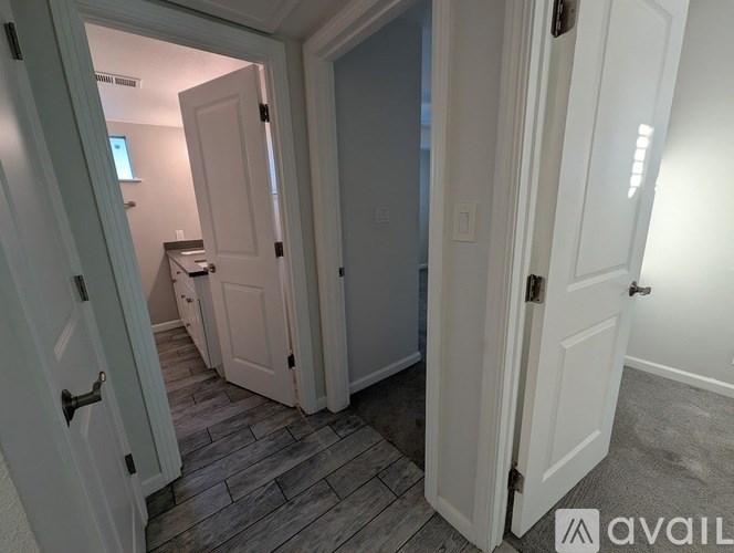 A room with a white door and a grey floor.