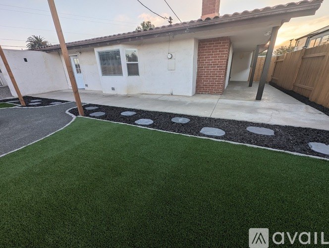 A house with a white exterior and a red brick chimney is for sale.
