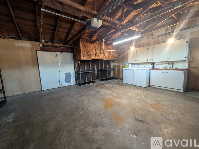 A large empty room with wooden ceiling and white cabinets.