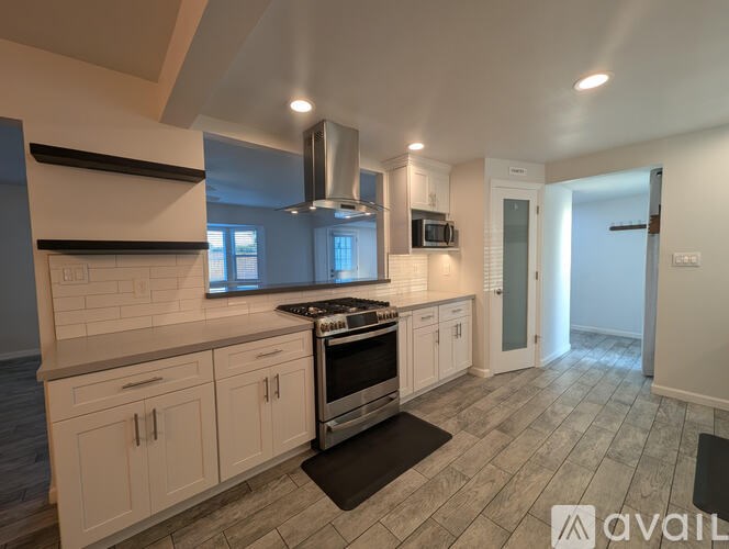 A kitchen with white cabinets and a black stove top oven.
