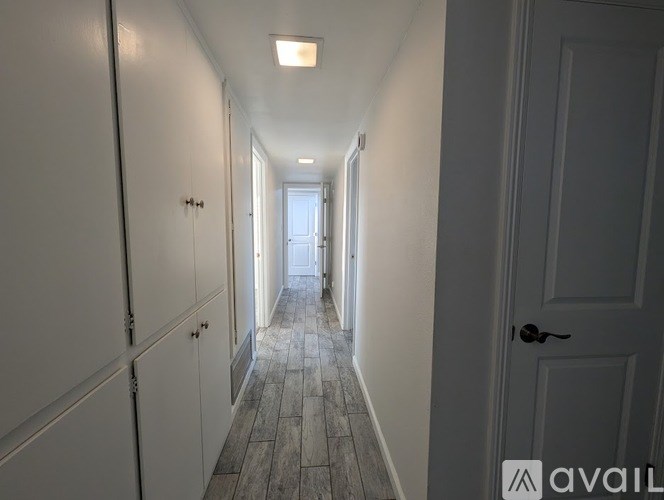 A long hallway with doors on both sides and a light at the end.