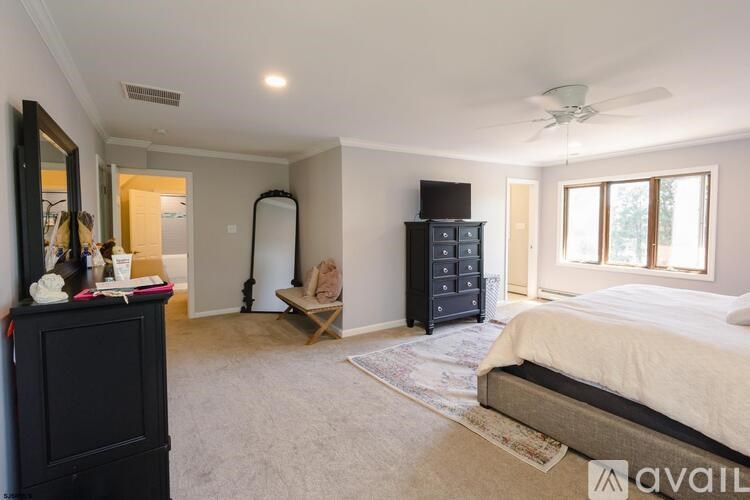 A bedroom with a large bed, a dresser, and a mirror.