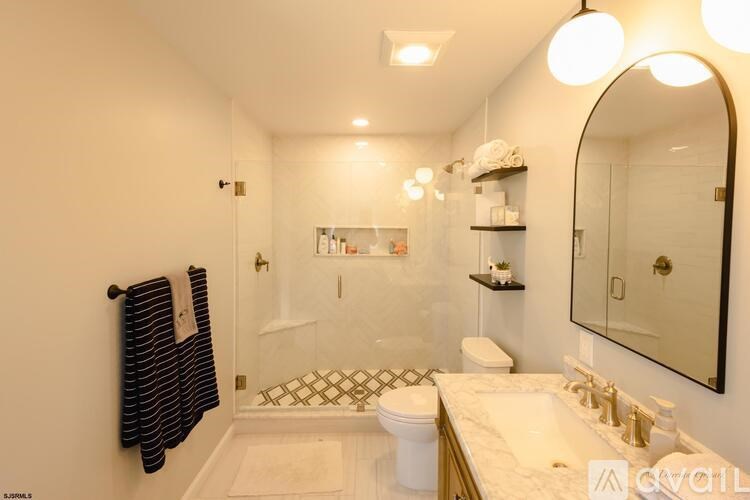 A bathroom with a white toilet, sink, and a mirror.