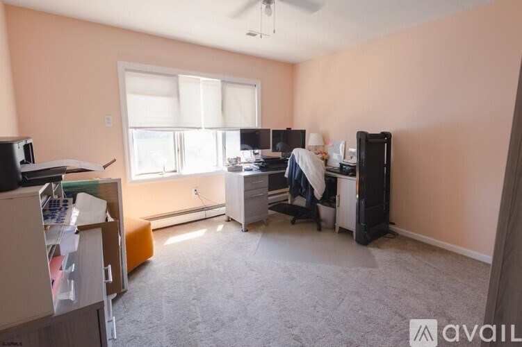A room with a desk, a chair, and a computer setup.
