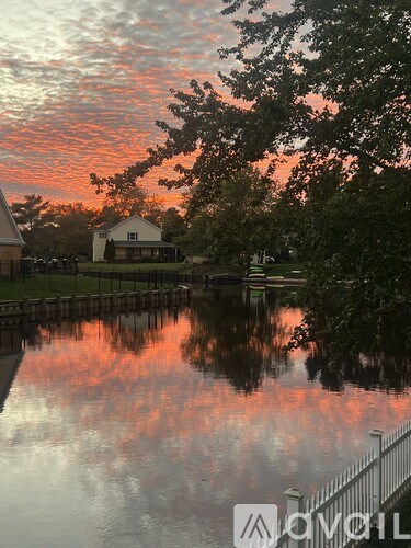 A house is reflected in the water by a dock.