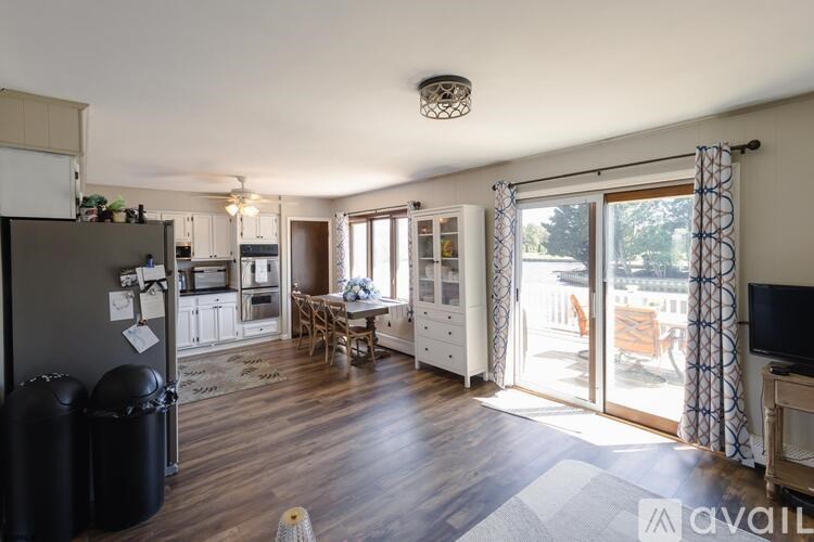 A kitchen with wooden floors and a dining area with a table and chairs.