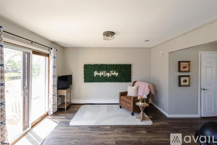 A living room with a green rug on the wall and a white couch.