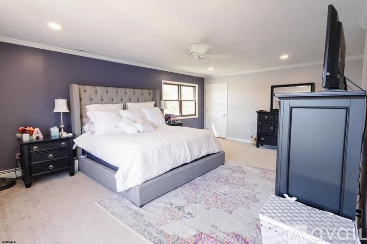 A bedroom with a large bed and a television.