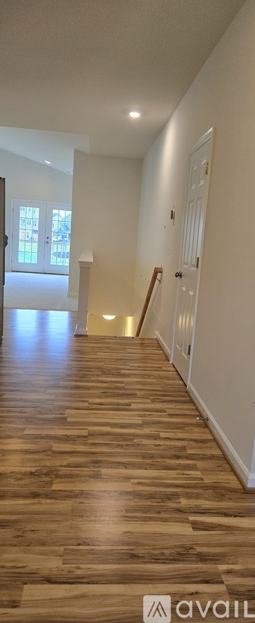 A long hallway with wooden floors and white walls.