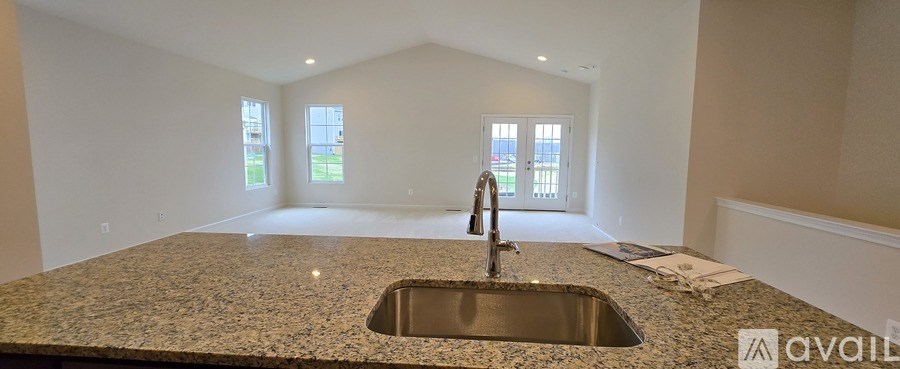 A kitchen countertop with a sink and a window in the background.