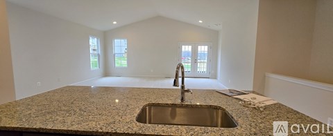 A kitchen countertop with a sink and a window in the background.