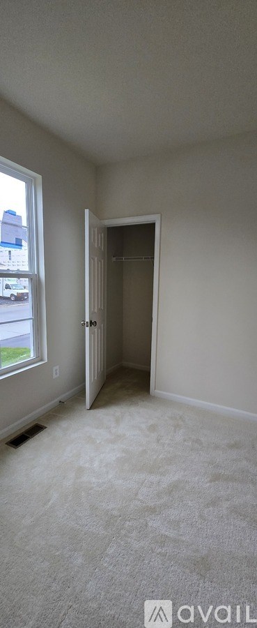 A room with a carpeted floor and a doorway leading to another room.