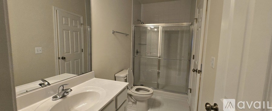 A bathroom with a toilet, sink, and shower.