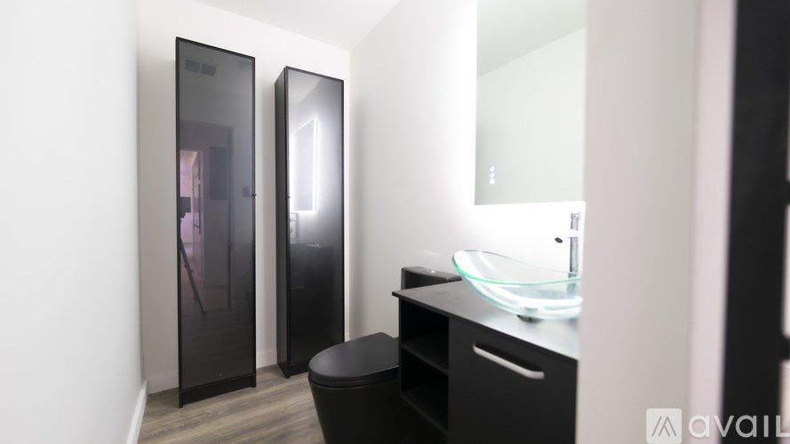 A bathroom with a sink, mirror, and a black cabinet.