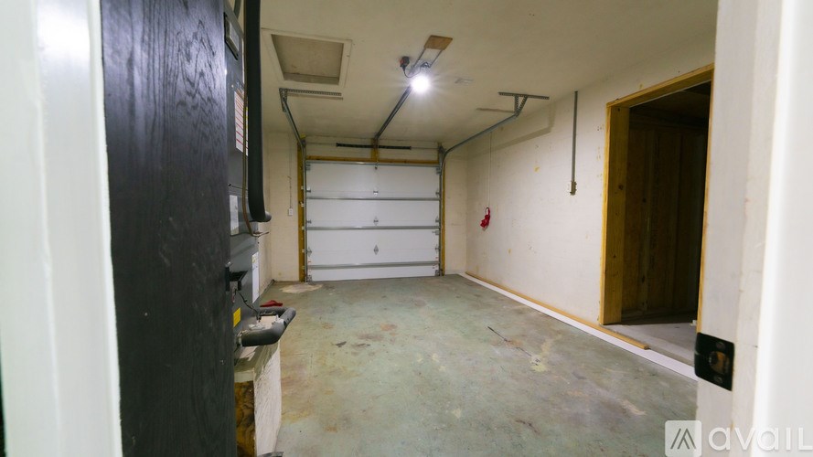 A room with a white fridge and a white door.