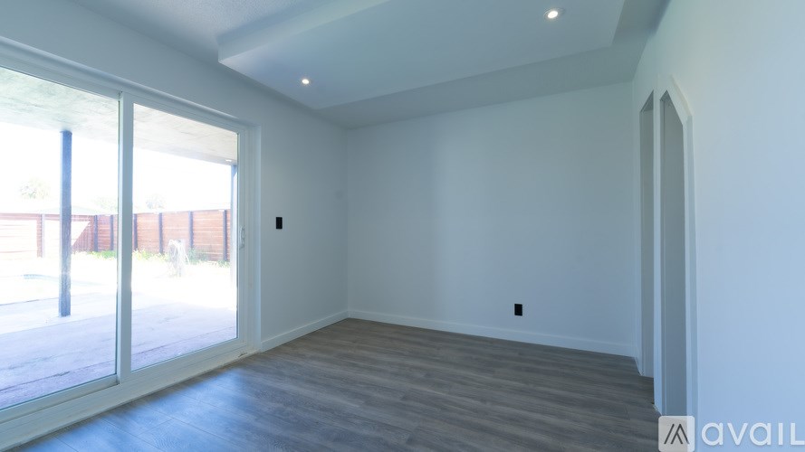 A room with a sliding glass door leading to a balcony.