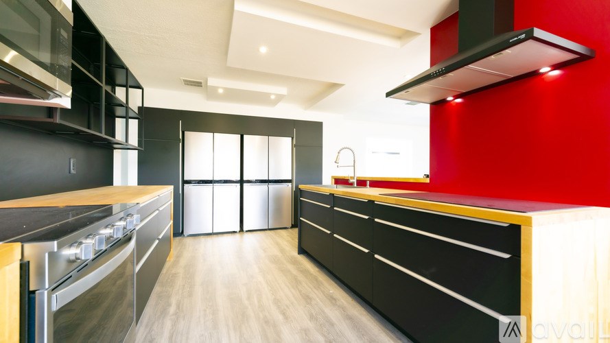 A modern kitchen with black cabinets and stainless steel appliances.