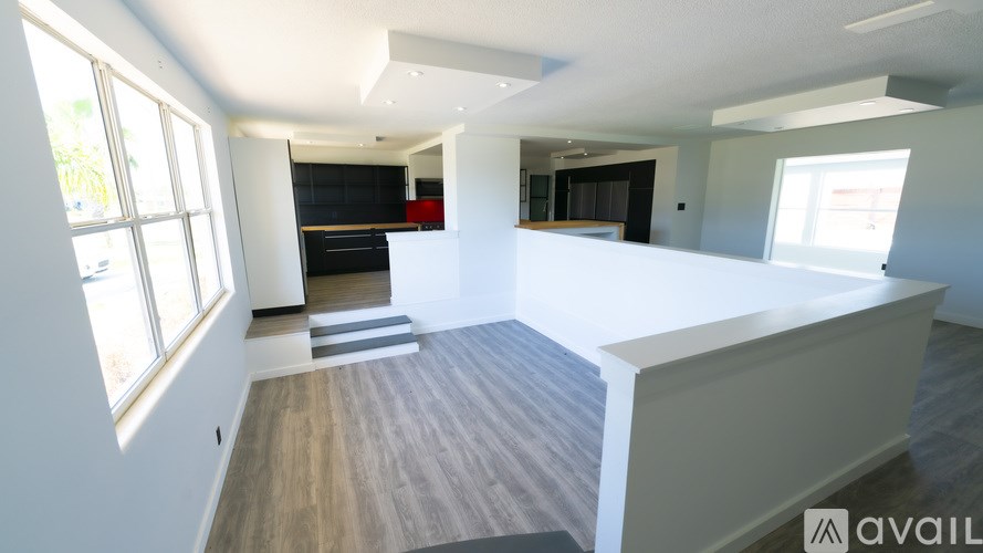 A spacious living room with a staircase leading to the upper level.