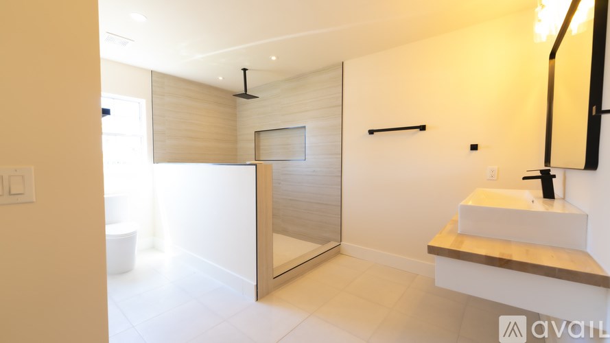 A modern bathroom with a walk-in shower and a sink.