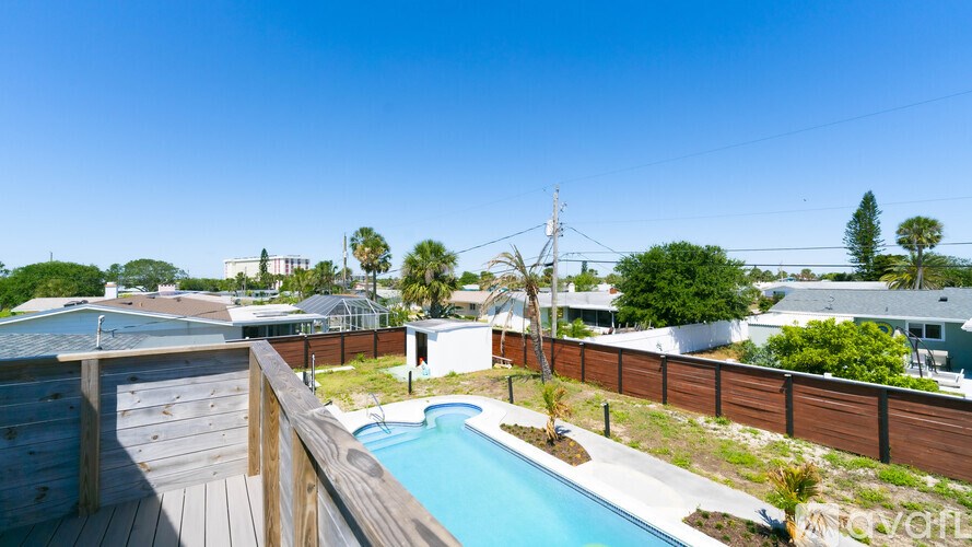 A pool surrounded by a wooden deck and a fence.