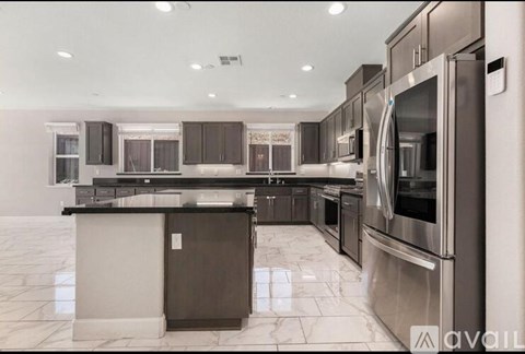 A modern kitchen with stainless steel appliances and a marble countertop.