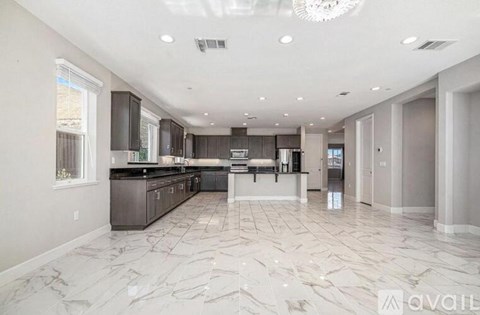 A spacious kitchen with marble flooring and modern appliances.