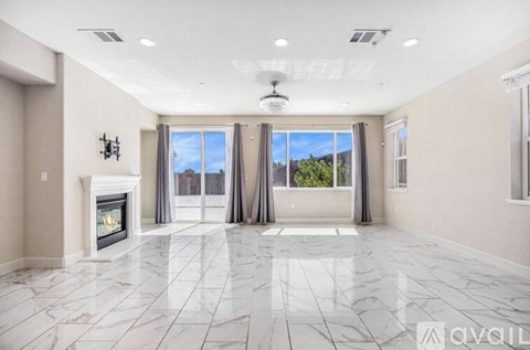 A spacious living room with a fireplace and large windows.