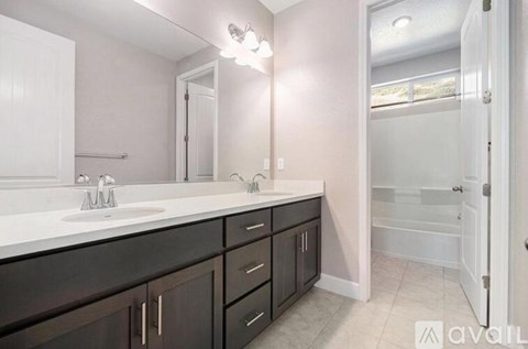 A bathroom with a white countertop and black cabinets.