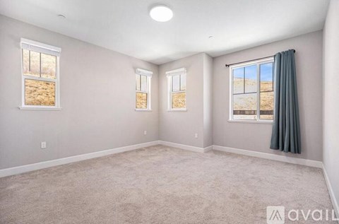 A room with two windows and carpeted floor.