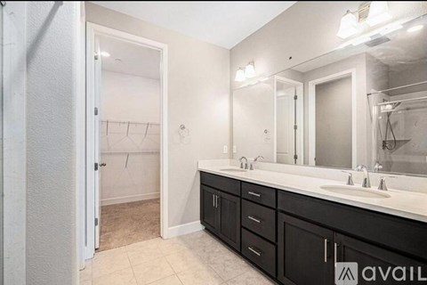 A bathroom with a vanity, sink, mirror, and a door leading to a closet.