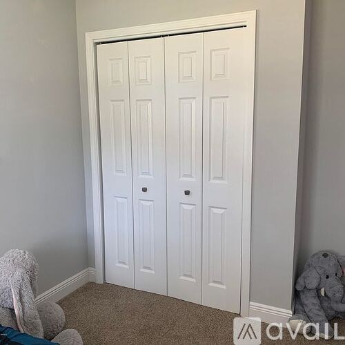 A white double door in a room with a carpeted floor.