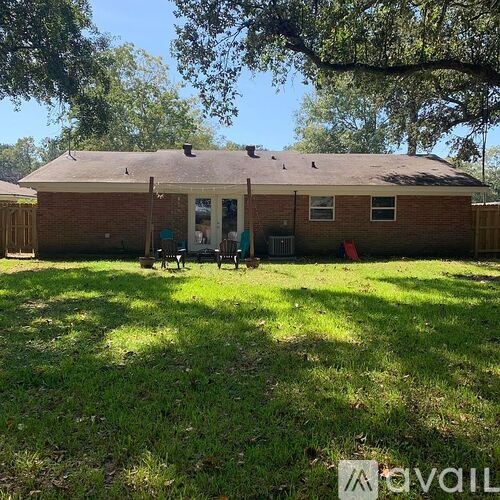 A house with a brown roof and a green lawn in front.