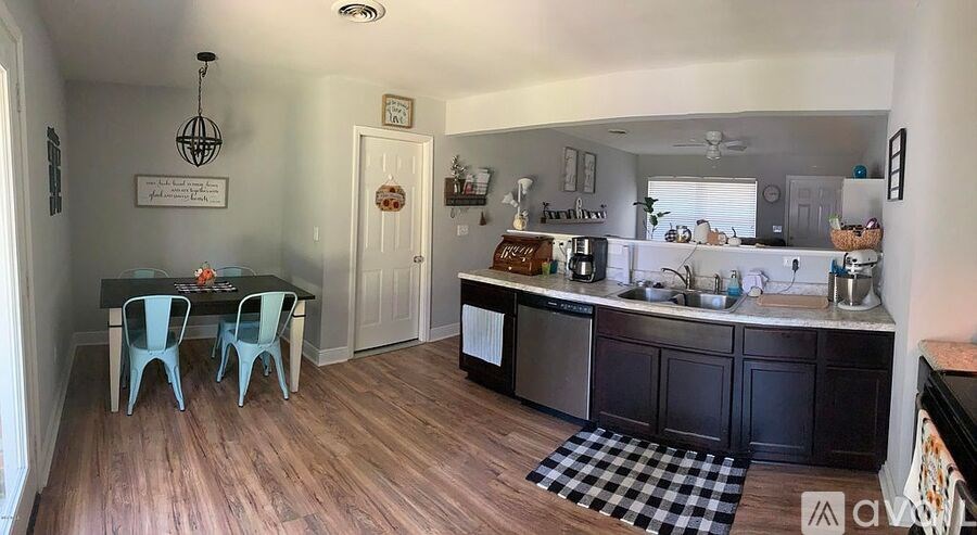 A kitchen with a table and chairs in front of a fridge.