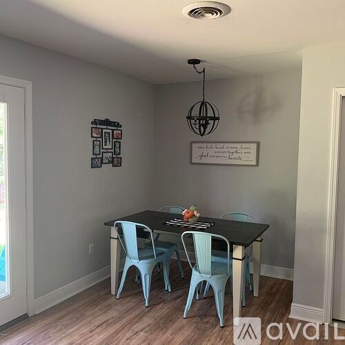 A dining room with a table and chairs.