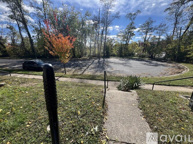 A park with a paved path and a metal railing.