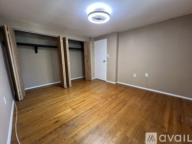 A room with wooden flooring and a ceiling light.