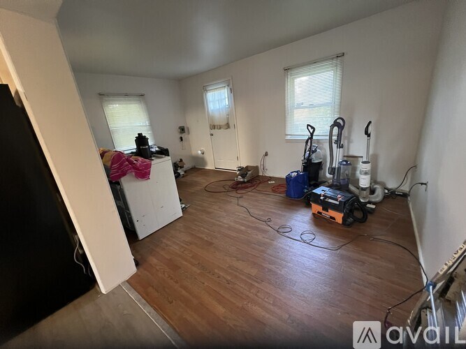 A room with wooden flooring and a vacuum cleaner on the floor.