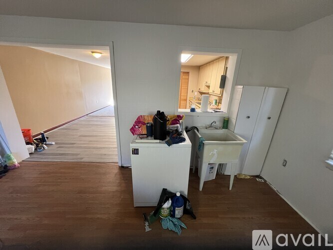A room with a white cabinet and a sink in it.