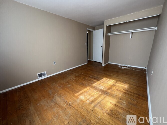 A room with wooden flooring and a sliding door.