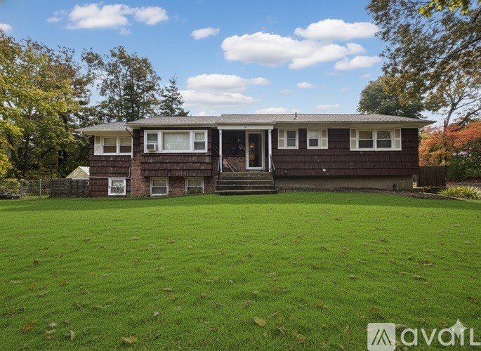 A brown house with a green lawn in front.