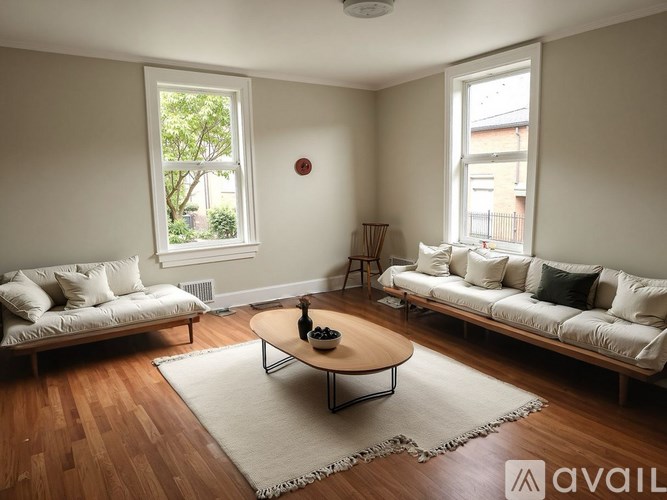 A living room with two couches, a coffee table, and a rug.