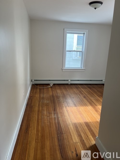 A room with wooden floors and a window.