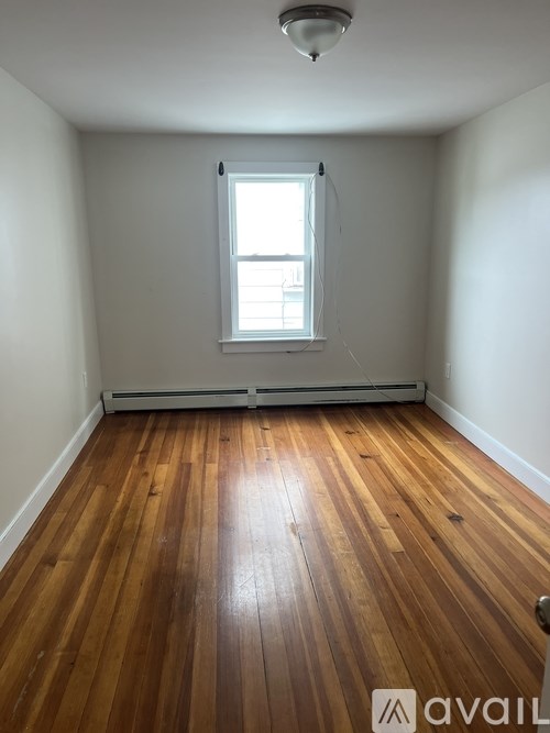 A room with wooden floors and a window.